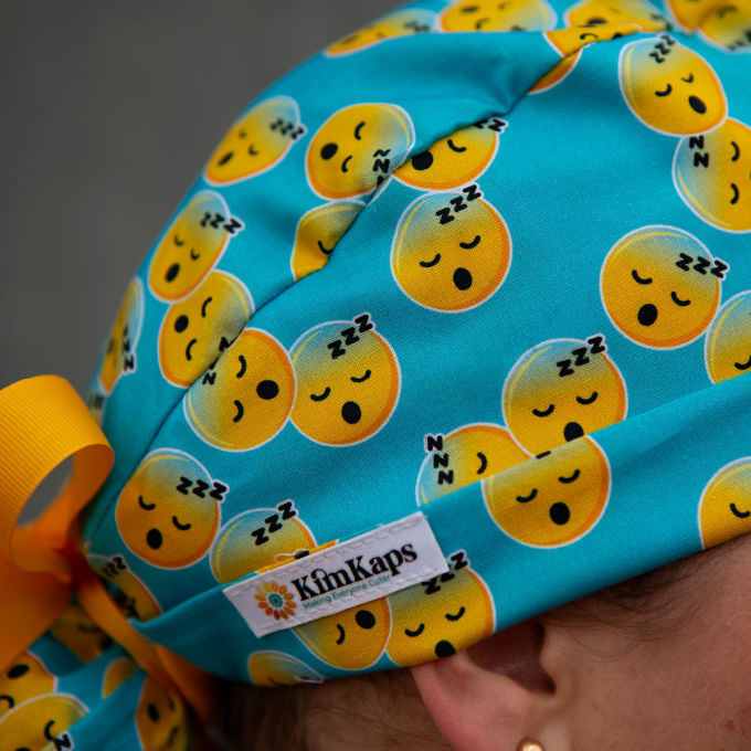 turquoise ponytail scrub cap with sleep emojis and yellow ribbon