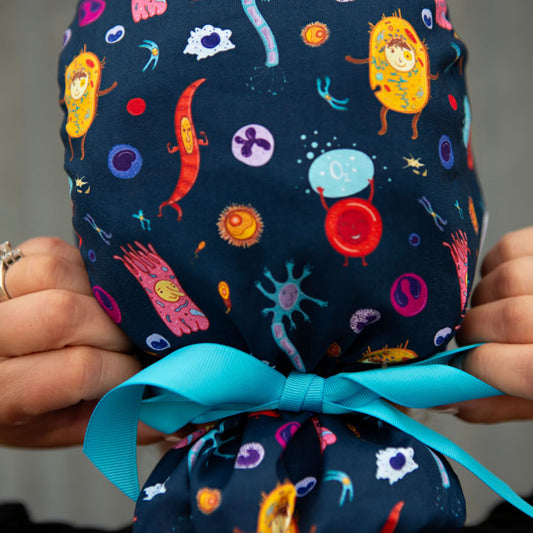navy scrub cap with different kinds of cells and a turquoise ribbon