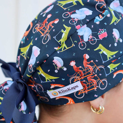 ponytail style scrub cap with animals riding bikes and scooters